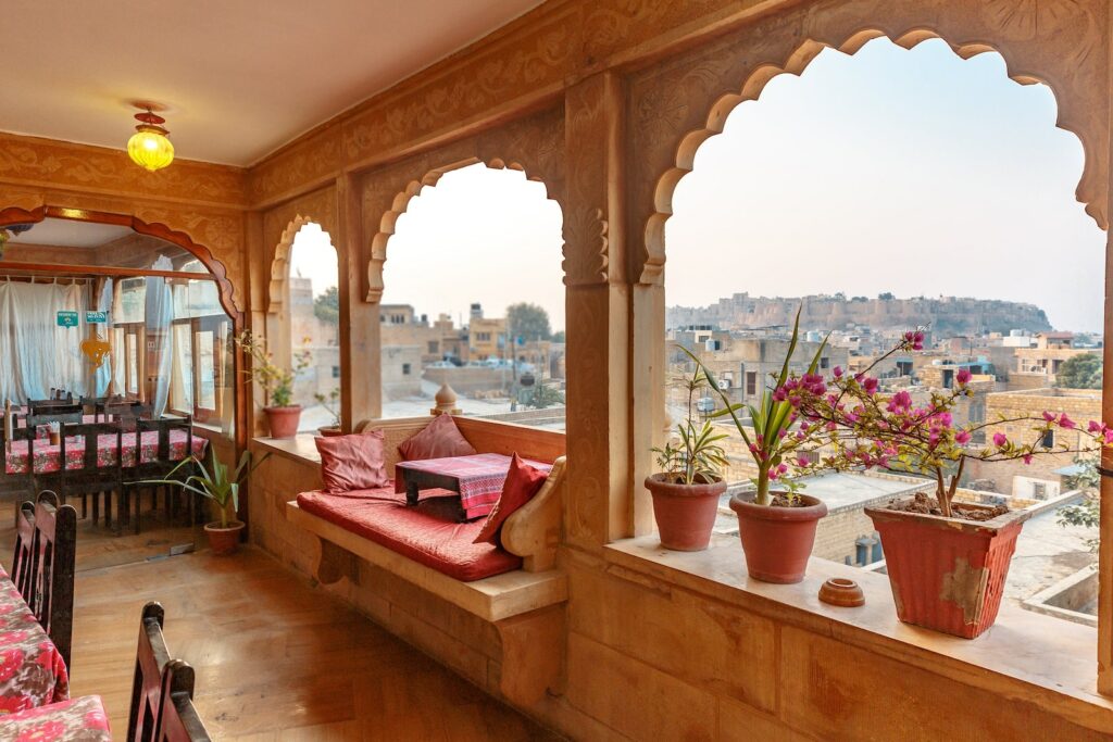 a room with a large window and a couch and potted plants